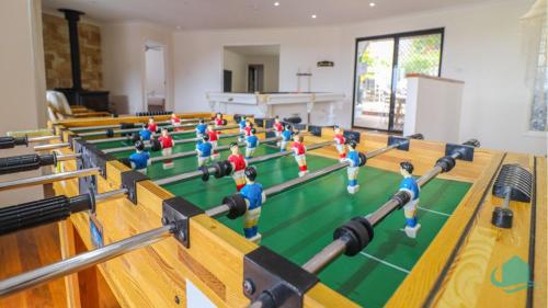 a group of people playing a game of table tennis at Splendour Hideaway - Luxury pool at Caves Beach in Caves Beach