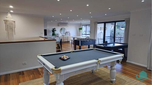 a living room with a pool table and a bar at Splendour Hideaway - Luxury pool at Caves Beach in Caves Beach