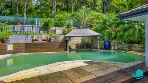 a swimming pool in a backyard with a gazebo at Splendour Hideaway - Luxury pool at Caves Beach in Caves Beach