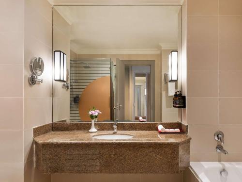 a bathroom with a sink and a mirror at Pullman Nairobi Upper Hill in Nairobi