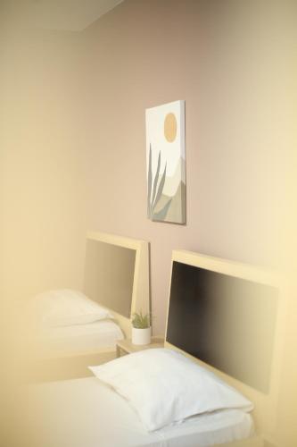 a bedroom with two beds and a picture on the wall at TekB Rooms & Apartments in Vlorë