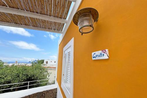 een gele muur met een bord erop en een raam bij Casa Corallo in Panarea