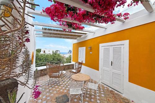 een balkon met een tafel, stoelen en bloemen bij Casa Corallo in Panarea