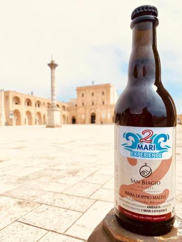 a bottle of beer sitting on a ledge in front of a building at Affittacamere 2 Mari in Marina di Leuca