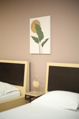 a bedroom with two beds and a table with a lamp at TekB Rooms & Apartments in Vlorë