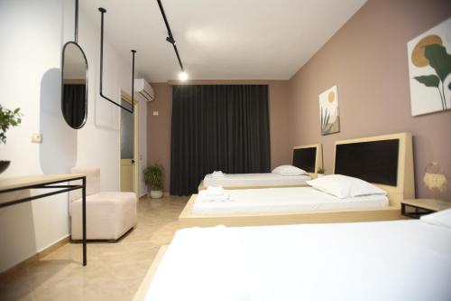 a bedroom with two beds and a mirror at TekB Rooms & Apartments in Vlorë