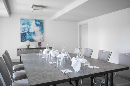 a dining room with a long table with chairs at Hotel Renovo Des Moines Urbandale,Tapestry Collection Hilton in Urbandale