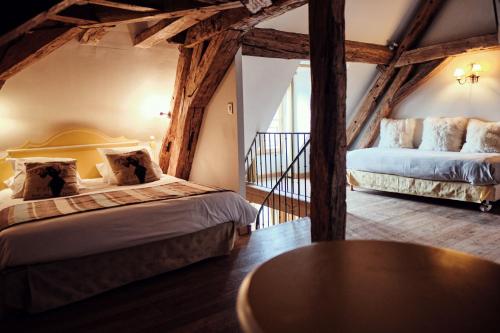 Hostellerie de la Tour d'Auxois في ساليو: غرفة نوم بسريرين وطاولة في غرفة