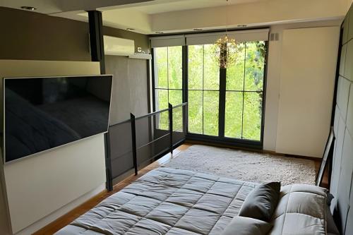Una sala de estar con un sofá y una ventana grande. en Luxury Apartment Palermo Hollywood, en Buenos Aires
