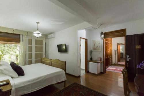 1 dormitorio con 1 cama y sala de estar en Boutique Hotel Colinas Petrópolis by Ateliê, en Petrópolis