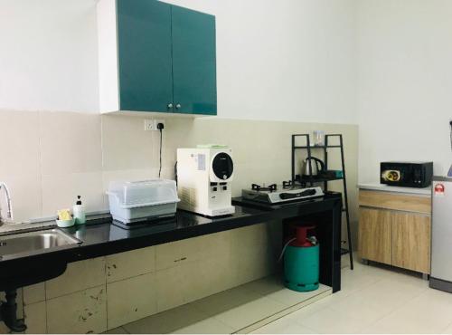 a kitchen with a counter with a sink and a microwave at De Lumpur Guest House in Kuantan