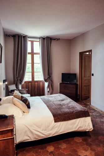 a bedroom with a large bed and a window at Hostellerie de la Tour d'Auxois in Saulieu