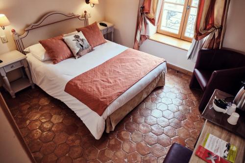 a bedroom with a large bed and a window at Hostellerie de la Tour d'Auxois in Saulieu