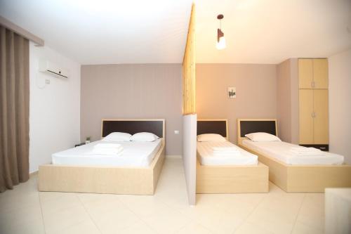 a room with two beds and a cross in it at TekB Rooms & Apartments in Vlorë