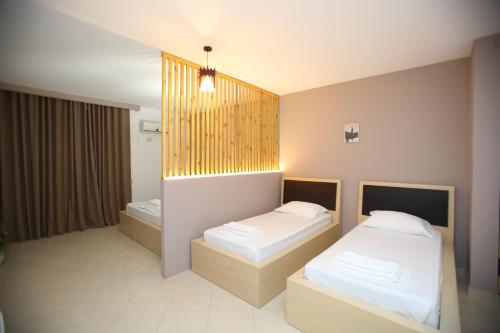 a room with two beds and a tub in it at TekB Rooms & Apartments in Vlorë
