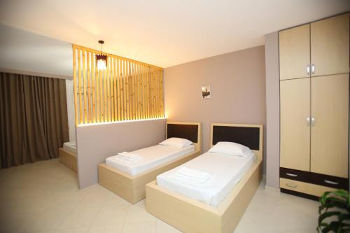 a bedroom with two beds and a window at TekB Rooms & Apartments in Vlorë