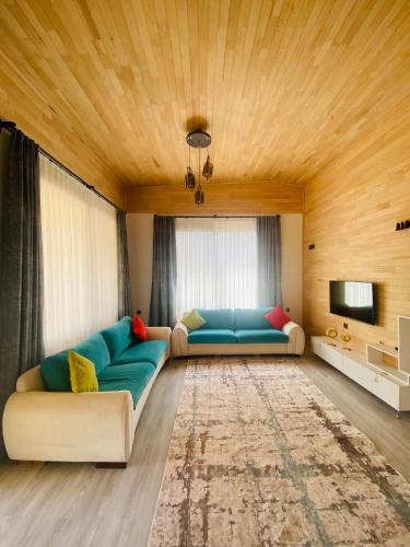 un salon avec un canapé bleu et une télévision dans l'établissement KARA KEDİ VİLLA'S, à Kemer