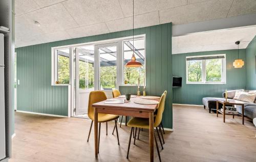a dining room with green walls and a table and chairs at Awesome Home In Give With Wifi in Give