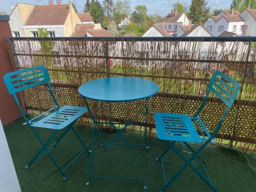 une table bleue et deux chaises sur un balcon dans l'établissement Appartement proche du centre Béthune, à Béthune