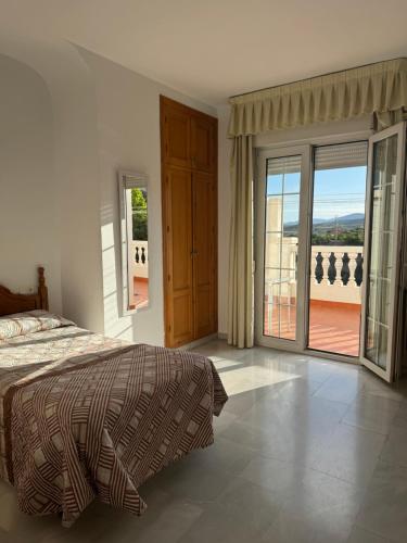 sypialnia z łóżkiem i drzwiami prowadzącymi na balkon w obiekcie Hotel Mirasol w mieście Órgiva