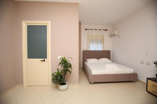 a bedroom with a bed and a potted plant at TekB Rooms & Apartments in Vlorë