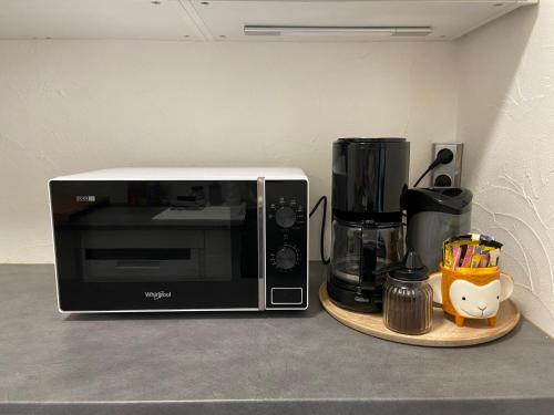 - un four micro-ondes assis sur un comptoir à côté d'une cafetière dans l'établissement Les Bleuets With Free Parking, à Boulogne-sur-Mer