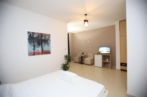 a room with a bed and a living room at TekB Rooms & Apartments in Vlorë