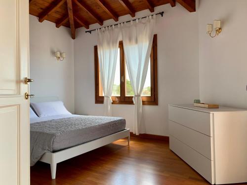 un dormitorio con una cama y una ventana en Sognatori Guest House - 400 mt from the Poetto beach, en Quartu SantʼElena