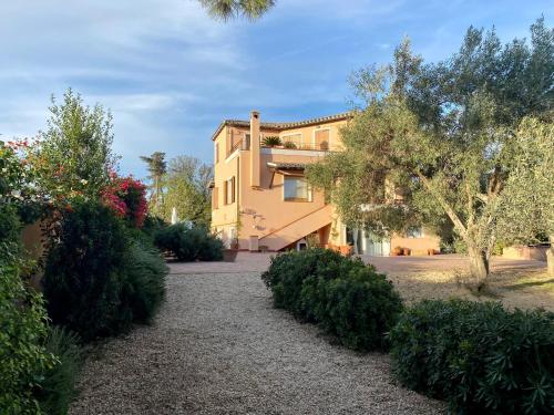 un edificio con árboles y arbustos delante de él en Sognatori Guest House - 400 mt from the Poetto beach, en Quartu SantʼElena