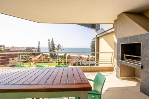Saints View Resort Unit 20 في أوفونغو بيتش: طاولة وكراسي على شرفة مطلة على المحيط