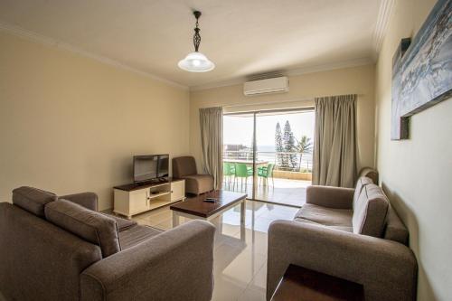 - un salon avec deux chaises et une télévision dans l'établissement Saints View Resort Unit 20, à Uvongo Beach
