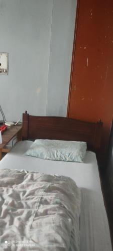 un letto non rifatto in una stanza con una parete arancione di Aurangzeb hotel a Rawalpindi
