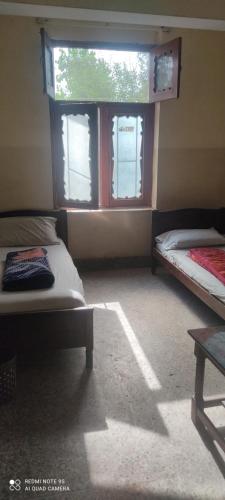 una camera con due letti davanti a una finestra di Aurangzeb hotel a Rawalpindi