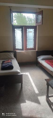 Aurangzeb hotel في روالبندي: غرفة بسريرين ونافذة