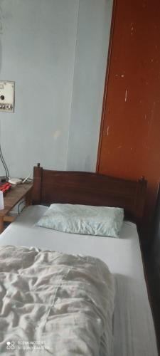 Aurangzeb hotel في روالبندي: سرير غير مرتب في غرفة نوم بحائط برتقالي