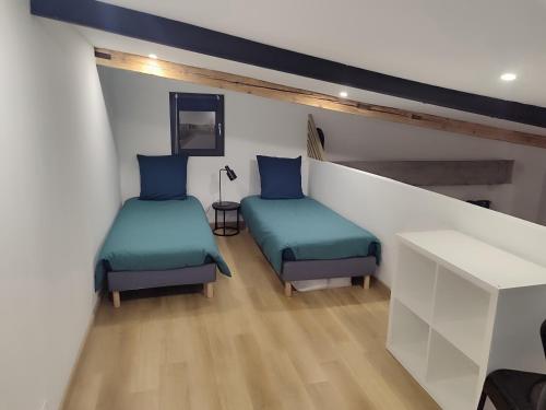 Habitación con 2 camas y mesa. en Le chaleureux loft 1 minute du tram, en Lingolsheim