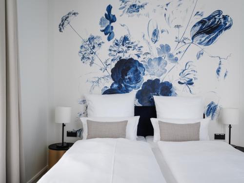 a bedroom with a bed with a blue and white wallpaper at AMERON Neuschwanstein Alpsee Resort & Spa in Schwangau