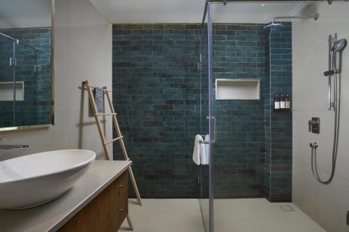 a bathroom with a sink and a glass shower at Mandrem Beach Resort, a member of Radisson Individuals Retreat in Mandrem
