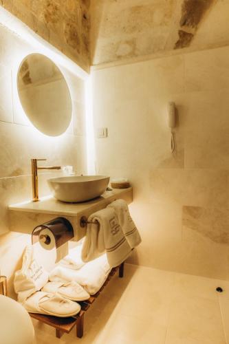 a bathroom with a sink and a mirror and towels at Via Regia Cappadocia Hotel in Uchisar