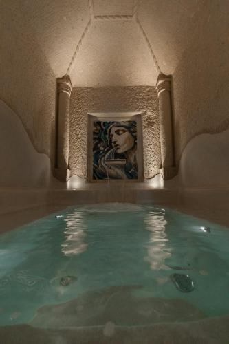 a pool of water in a room with a painting at Via Regia Cappadocia Hotel in Uchisar