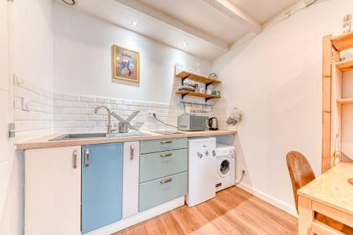 une cuisine avec un évier et une machine à laver dans l'établissement GuestReady - Beau Séjour à La Croix-Rousse, à Lyon
