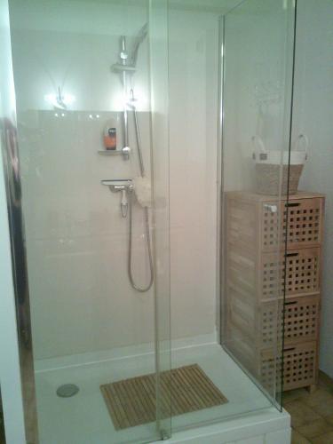 une douche avec une porte vitrée dans une salle de bain dans l'établissement Vittoria immobilier-PACIFIC PLAGE - Chèques Vacances acceptés., à La Grande Motte