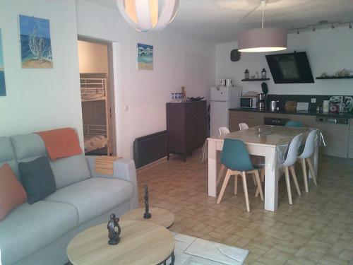 un salon et une cuisine avec un canapé et une table dans l'établissement Vittoria immobilier-PACIFIC PLAGE - Chèques Vacances acceptés., à La Grande Motte