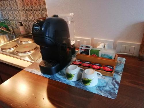 a black coffee maker sitting on a counter with cups at Piazza Matteotti 10 in Assisi