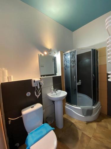 a bathroom with a shower and a toilet and a sink at Hacienda in Sopot