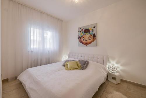 een slaapkamer met een wit bed met een schilderij aan de muur bij Leona apartment in Split