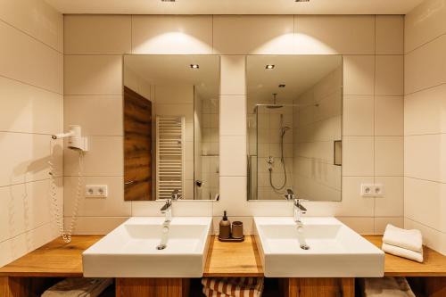 2 lavabos en un baño con 2 espejos en Appartements Gladbach, en Heiterwang
