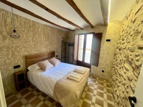 a bedroom with a large bed in a stone wall at Casa Raquel Montanejos in Montanejos