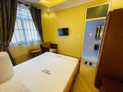 Cette petite chambre comprend un lit et une fenêtre. dans l'établissement Dodoma Star Lounge, à Dodoma