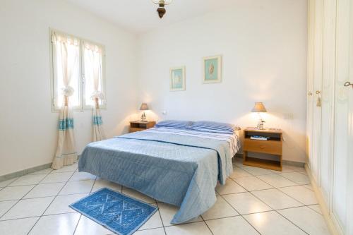 a white bedroom with a bed and two night stands at Casa Rockefeller in San Teodoro